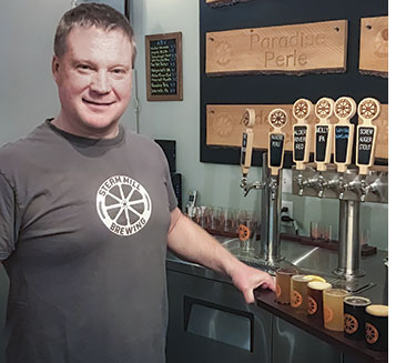 Scott Fraser pours a flight of brews at Steam Mill Brewing. Photo: Carey Kish