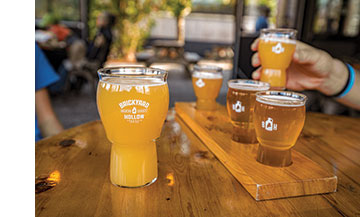 A pint of Trestle IPA and a flight of four different beers are served on Brickyard Hollow's enclosed outdoor space.